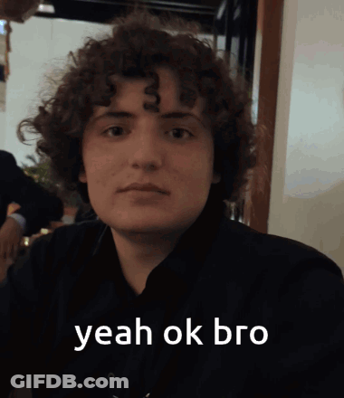 A Young Man With Curly Hair Says " Yeah Ok Bro " In White Letters GIF