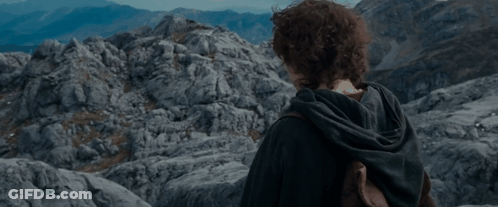 A Young Man With Curly Hair Stands In Front Of A Mountain GIF
