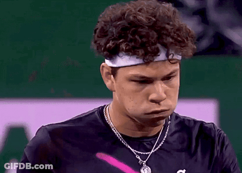 A Young Man With Curly Hair Wearing A Headband And A Necklace GIF