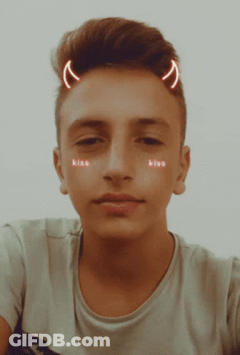 A Young Man With Devil Horns On His Head Has The Word Kiss On His Face GIF