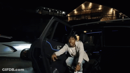 A Young Man With Dreadlocks Is Sitting In A Car And Smiling GIF