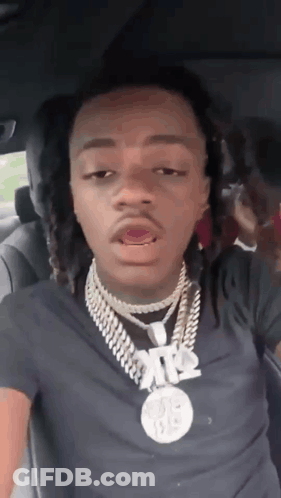 A Young Man With Dreadlocks Is Sitting In The Back Seat Of A Car . GIF