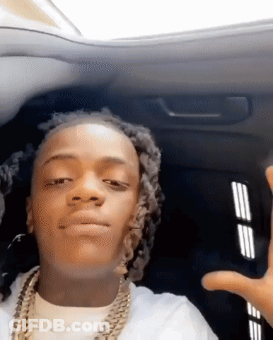 A Young Man With Dreadlocks Is Sitting In The Back Seat Of A Car And Making A Funny Face . GIF