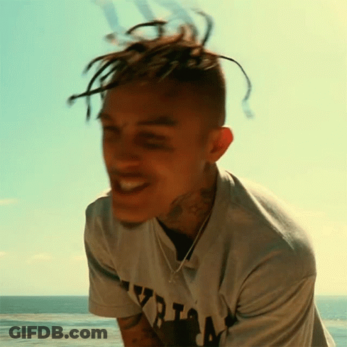 A Young Man With Dreadlocks Is Wearing A Shirt That Says ' Yzria ' On It GIF