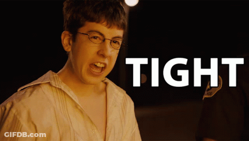 A Young Man With Glasses Is Screaming In Front Of A Sign That Says Tight GIF