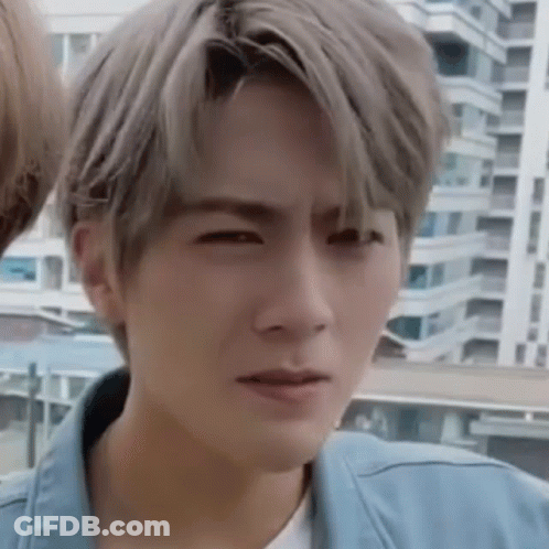 A Young Man With Gray Hair Is Making A Funny Face . GIF