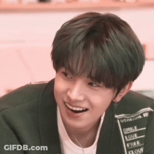 A Young Man With Green Hair Is Smiling And Wearing A Shirt That Says Smile Love Free And Flour GIF