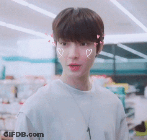 A Young Man With Hearts Drawn On His Face And A Necklace With The Number 1 On It GIF
