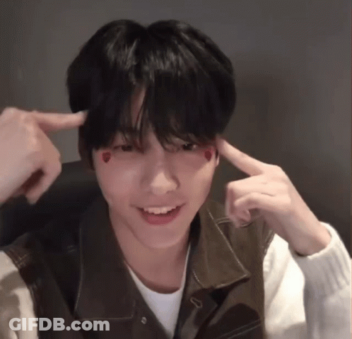 A Young Man With Hearts On His Face Is Making A Funny Face With His Fingers . GIF