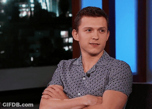 A Young Man With His Arms Crossed And A Microphone On His Shirt GIF