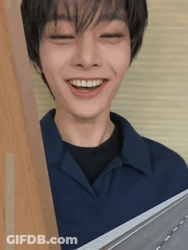 A Young Man With His Eyes Closed Is Smiling GIF