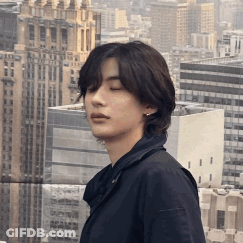 Young Man With Eyes Closed In Cityscape GIF