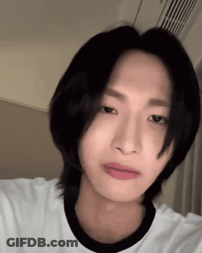 A Young Man With Long Black Hair Is Wearing A White Shirt With A Black Collar GIF