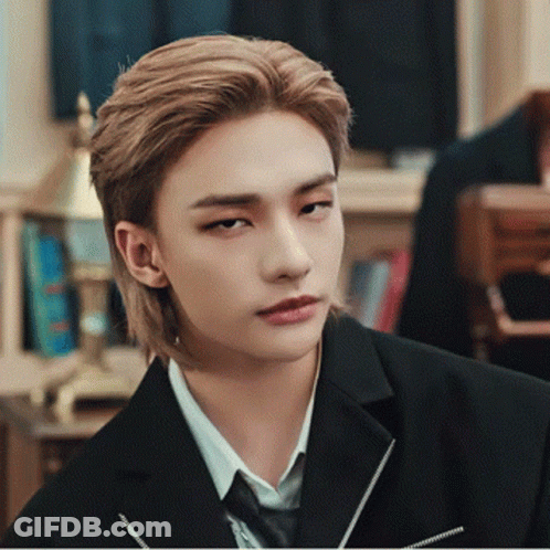 A Young Man With Long Blonde Hair Wearing A Suit And Tie GIF