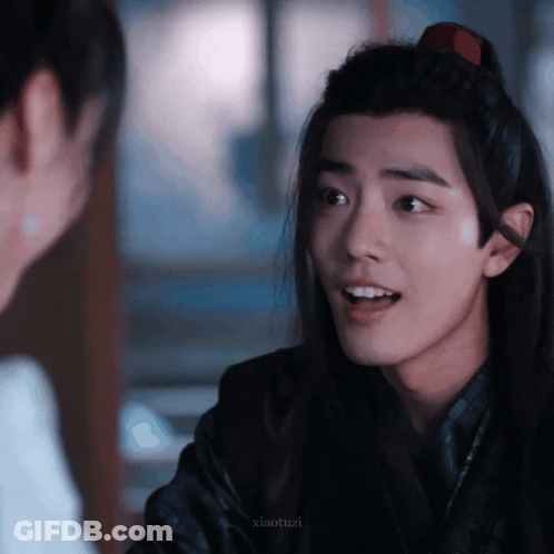 A Young Man With Long Hair Is Talking To Another Man GIF