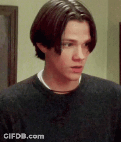 A Young Man With Long Hair Is Wearing A Black Sweater GIF