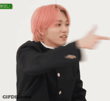 A Young Man With Pink Hair Is Pointing At Something With His Finger . GIF
