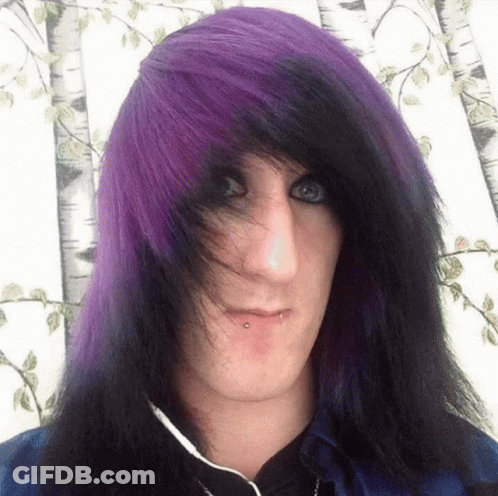 A Young Man With Purple And Black Hair Is Wearing Headphones GIF