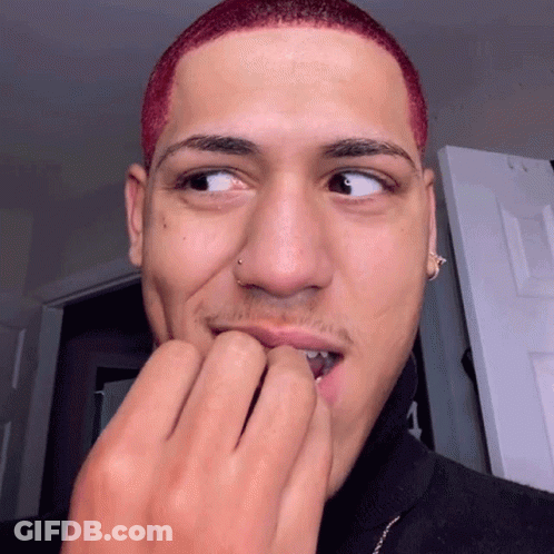 A Young Man With Red Hair And A Nose Ring Is Biting His Nails GIF