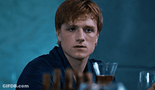 A Young Man With Red Hair Is Holding A Glass Of Wine GIF