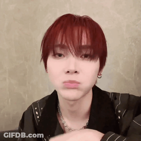 A Young Man With Red Hair Is Making A Funny Face While Wearing A Necklace And Earrings . GIF