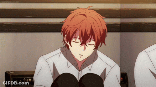 A Young Man With Red Hair Is Sitting With His Eyes Closed GIF