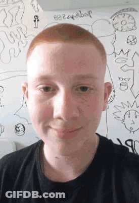 A Young Man With Red Hair Is Standing In Front Of A White Board With Drawings On It . GIF