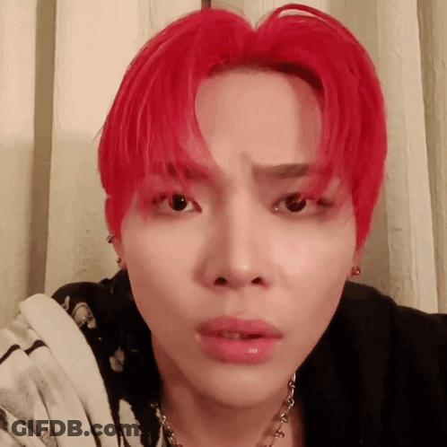 A Young Man With Red Hair Is Wearing A Black Shirt And A Necklace GIF