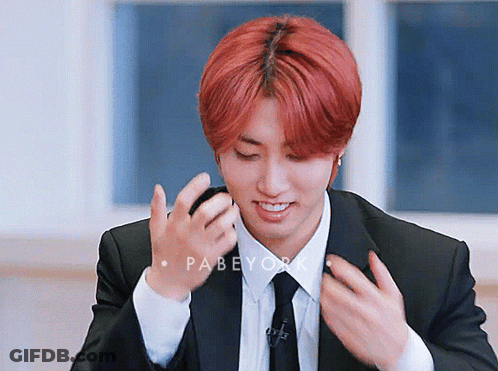 A Young Man With Red Hair Is Wearing A Suit And Tie .. GIF