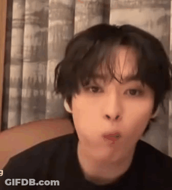 A Young Man With Short Hair Is Making A Funny Face While Sitting In Front Of A Window . GIF