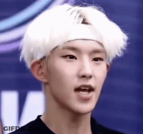 A Young Man With White Hair And A Headband On His Head Is Making A Funny Face . GIF