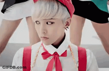 A Young Man With White Hair And A Red Hat Is Wearing Suspenders And A Bow Tie . GIF