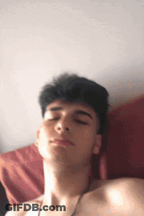 A Young Man Without A Shirt Is Laying On A Bed With His Eyes Closed GIF