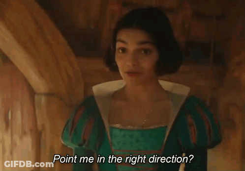 A Young Woman In A Green Dress Is Standing In A Room And Smiling . GIF