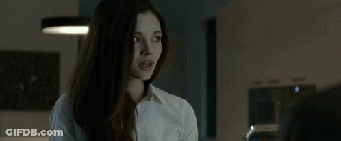 A Young Woman In A White Shirt Is Talking To A Man In A Kitchen . GIF