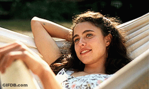 A Young Woman Is Laying In A Hammock With Her Head Resting On Her Arm GIF