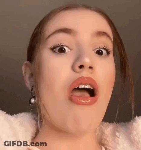 A Young Woman Is Making A Funny Face With Her Mouth Open . GIF
