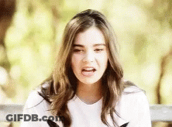 A Young Woman Is Sitting On A Bench With Her Mouth Open . GIF