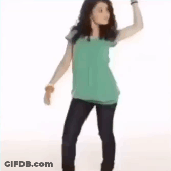 A Young Woman Is Standing With Her Hands On Her Hips . GIF