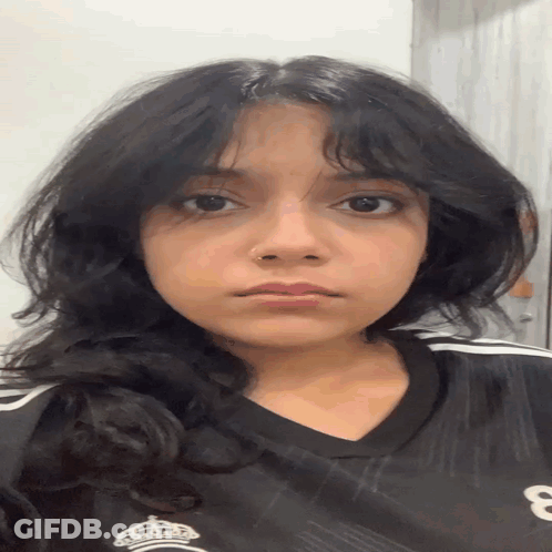 A Young Woman Wearing A Black Shirt With The Number 8 On It GIF