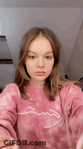 A Young Woman Wearing A Pink Tie Dye Sweatshirt Is Taking A Selfie . GIF