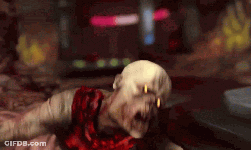 A Zombie With Blood Coming Out Of His Mouth Is Laying On The Ground . GIF
