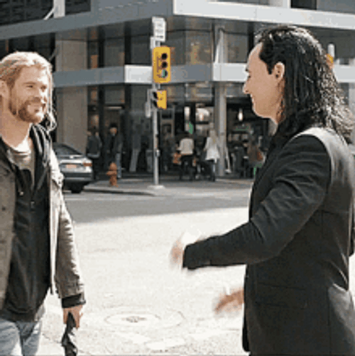 Actors Chris Hemsworth And Tom Hiddleston Hand Signs GIF
