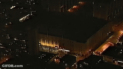 Aerial Night City With Large Lit Building GIF