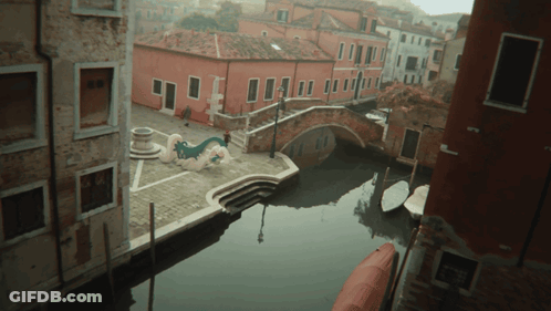 Aerial View Of Narrow Canal With Boats And Buildings GIF