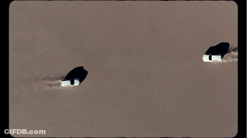 Aerial View Of Two Cars Driving Through The Sand GIF