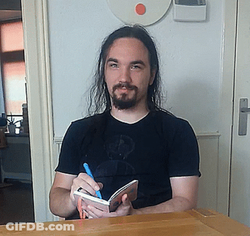 ALF Sitting At Desk With Pen GIF