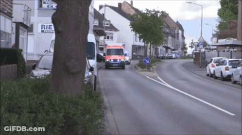 Ambulance Driving Past Store Saying Rie GIF