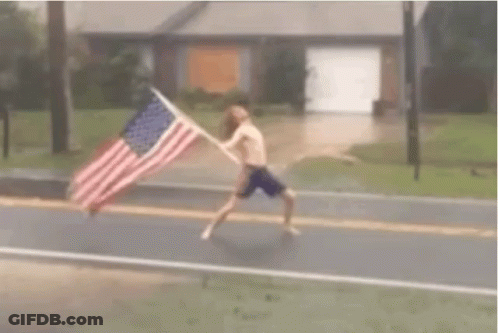 American Flag Flying In Wind Over Blue Sky GIF