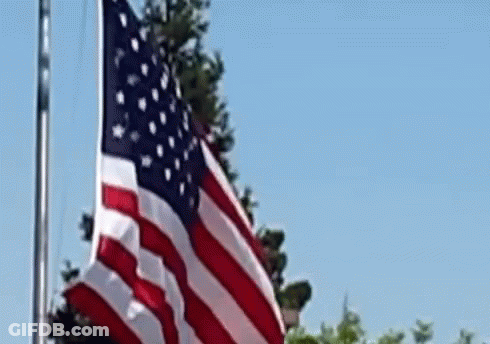 American Flag Waving Against Blue Sky GIF